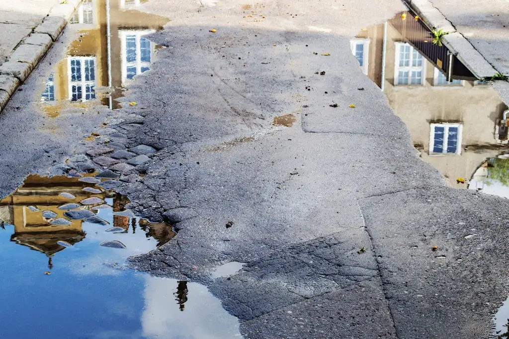 Chemin abîmé avec des fissures et des trous avant la réparation